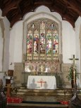 The stone reredos does not overwhelm a pretty sanctuary.