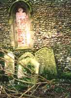 Disturbed graves lean against the east tower wall.