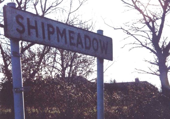 The workhouse broods on the hilltop beyond the village sign